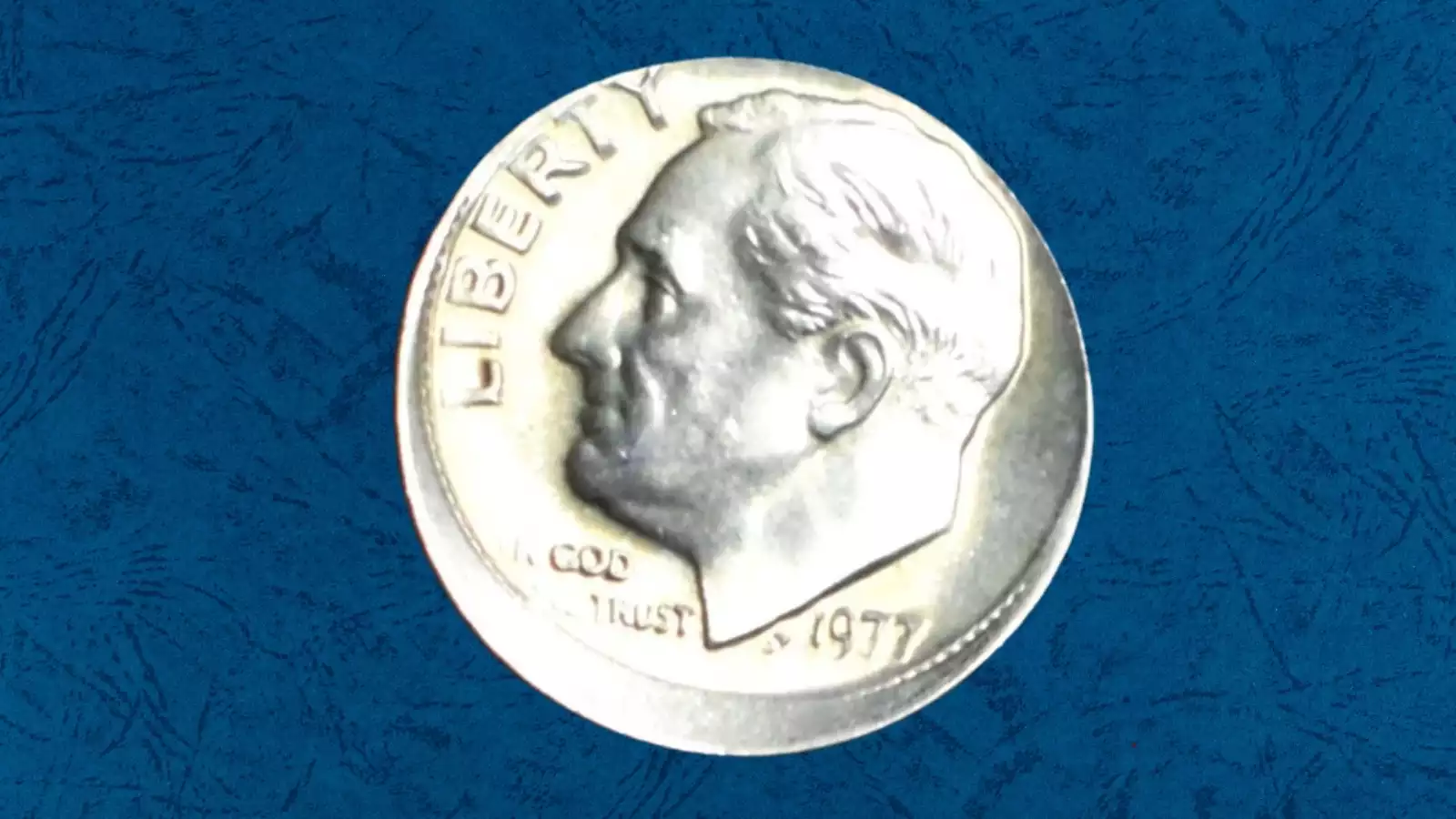 1977 Roosevelt dime off-center strike error showing crescent of blank metal opposite the shifted design